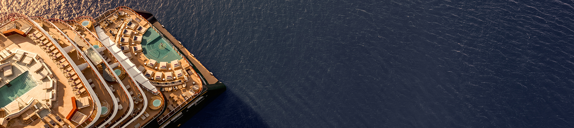Aerial view of an Explora Journeys cruise ship at sea during sunset